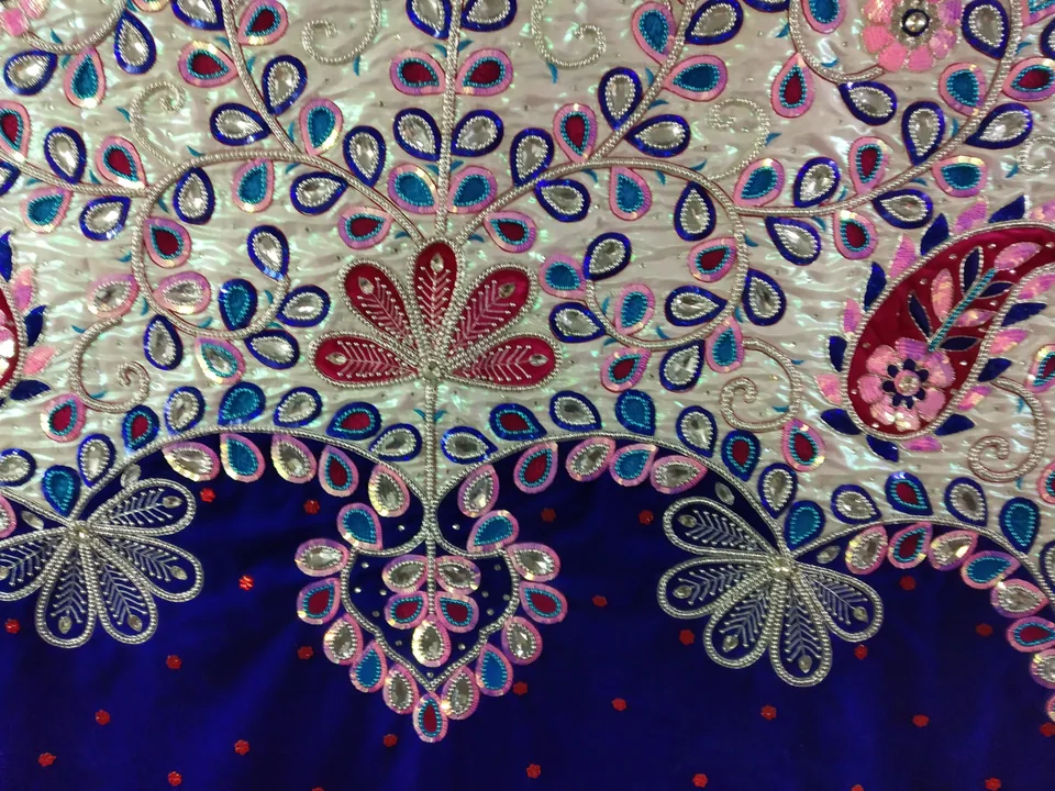 Close view of blue and pink leaf shapes, floral outlines and silver-coloured decoration on a cream and blue backdrop
