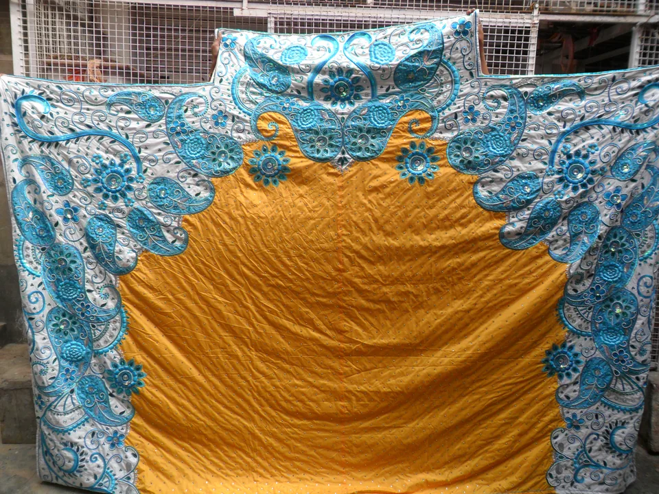 Large backdrop with blue scrolling motifs on a pale border surrounding a yellow centre