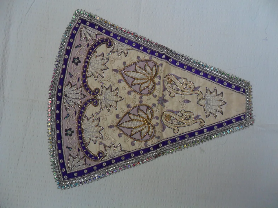 Cream-coloured tapered garment panel outlined with purple floral and leafy embroidery