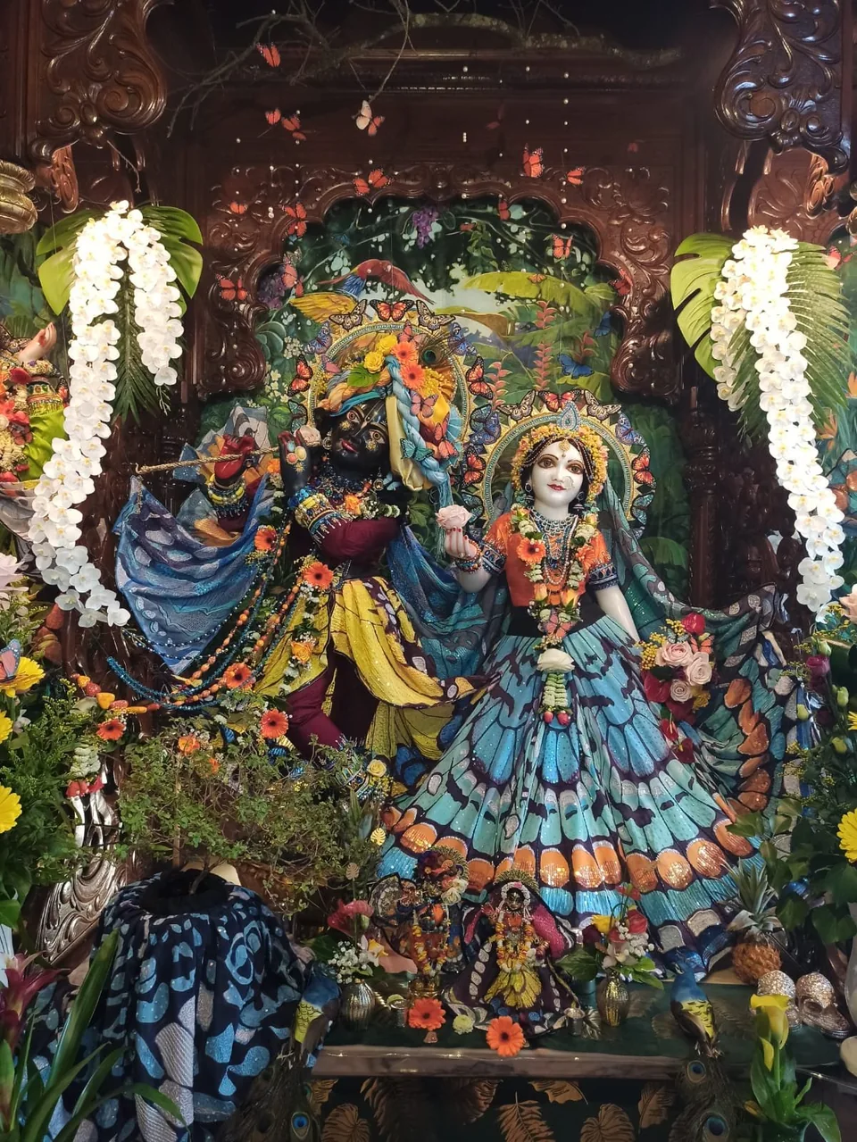 Deities dressed in green and gold embroidered attire