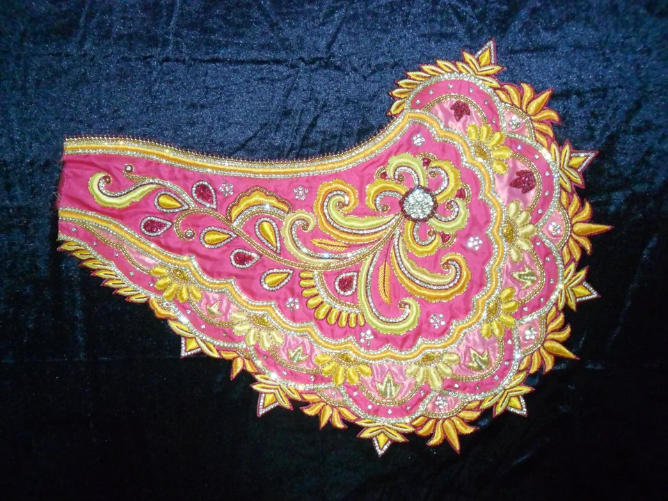 Curved pink panel with yellow and pale curled motifs and repeated leaf-shaped details at its edge