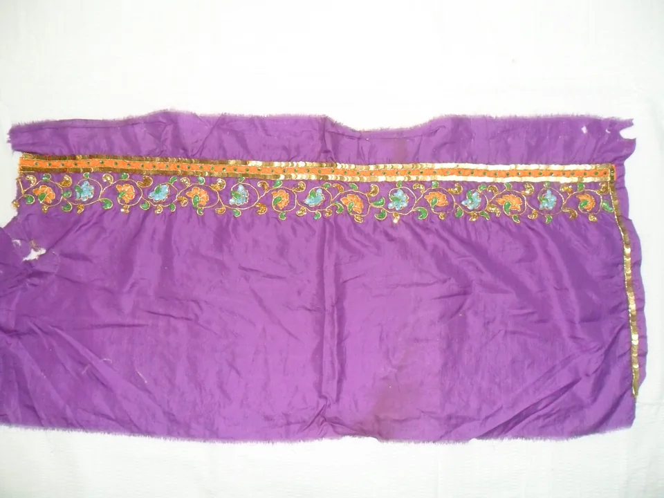 Purple cloth laid flat with a narrow gold-coloured and floral decorated border