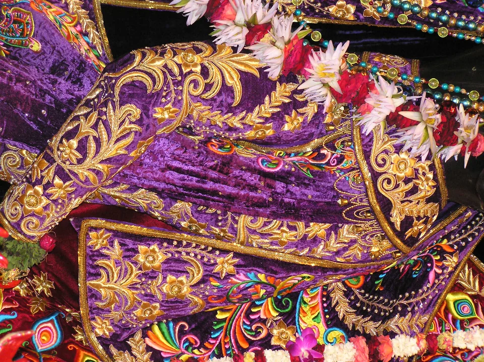 Purple fabric decorated with gold-coloured leaves and multicoloured embroidered details