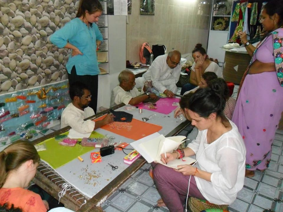 Participants gathered around embroidery frames in a hand embroidery workshop