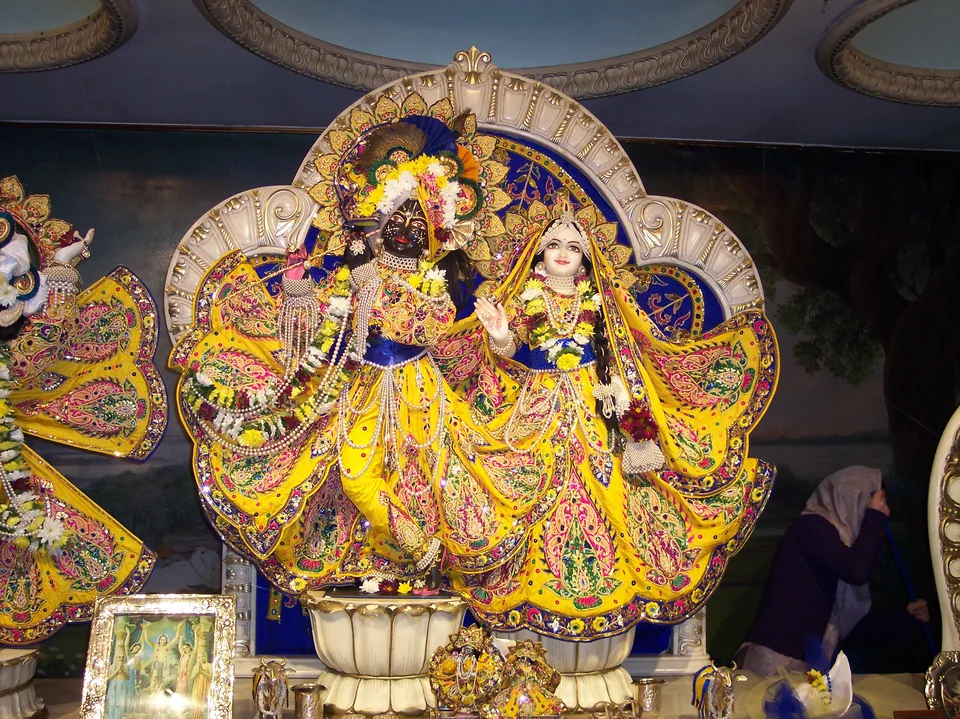 Radha Krishna in yellow attire with blue accents and multicoloured embroidered motifs